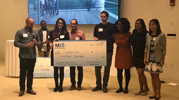 MIT MBA student Javier Renna (left) presents the MIT Water Prize winners with their award.