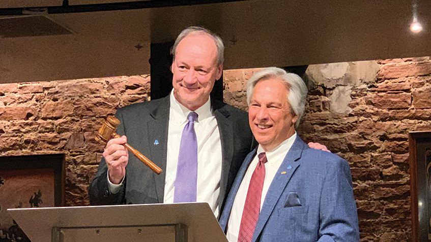 Jim Williams (left) accepts the gavel from David Rager during AWWA&rsquo;s ACE 2019 conference in Denver. Photo courtesy SUEZ N.A.
