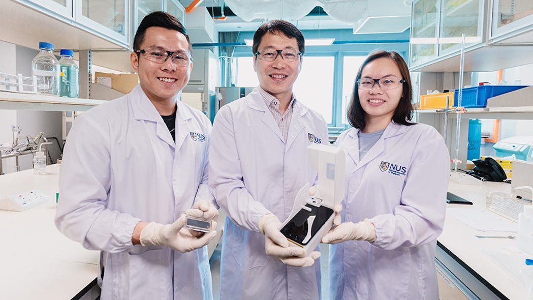 The NUS research team behind the novel algae detection device is led by Assistant Professor Bae Sung Woo (centre) who is holding the smartphone platform. With him are two team members: Mr Thio Si Kuan (left) who is holding the microfluidic chip, and Miss Chiang Li Ching Elaine (right).