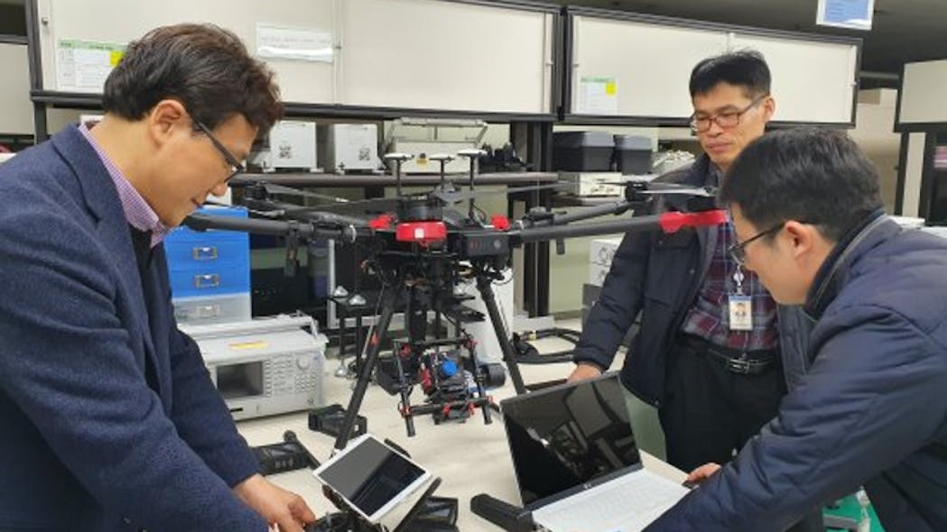 ETRI researchers inspect their hyperspectral camera drone.