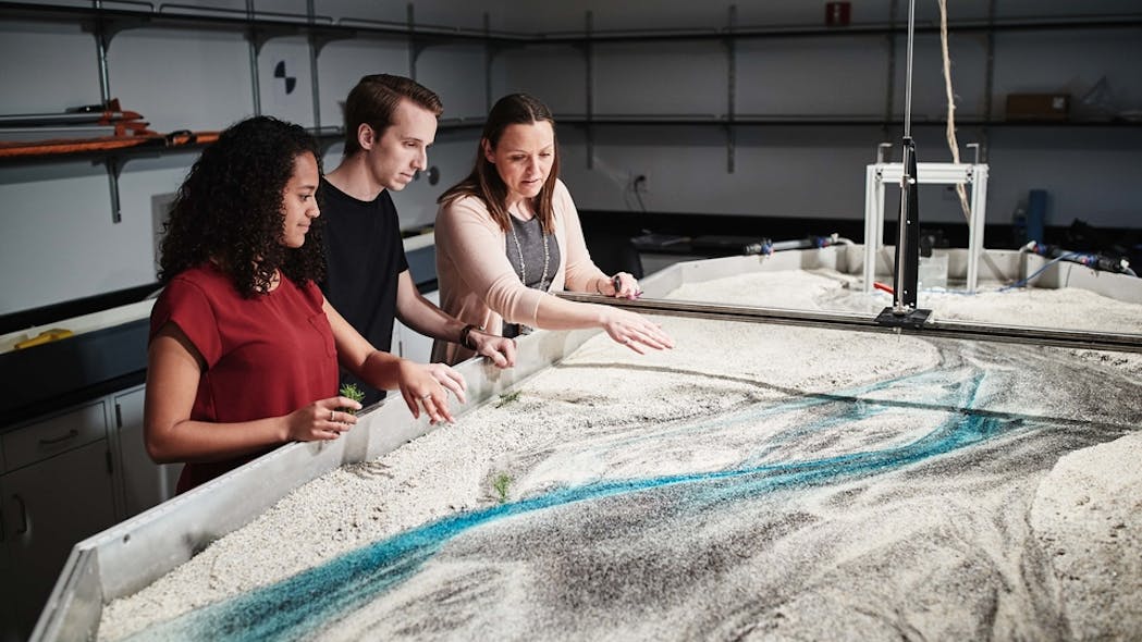 Far right) Amanda Cox, Ph.D., director of the newly launched WATER Institute, works with students examining a water flow model.