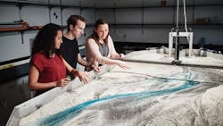 Far right) Amanda Cox, Ph.D., director of the newly launched WATER Institute, works with students examining a water flow model. Far right) Amanda Cox, Ph.D., director of the newly launched WATER Institute, works with students examining a water flow model.
