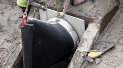 A Tideflex&circledR; TF-1 Check Valve being installed on the headwall, notice the large amount of mud.