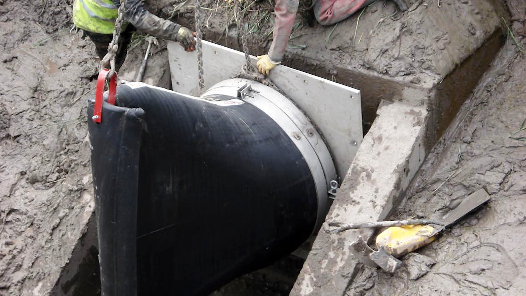 A Tideflex&circledR; TF-1 Check Valve being installed on the headwall, notice the large amount of mud.