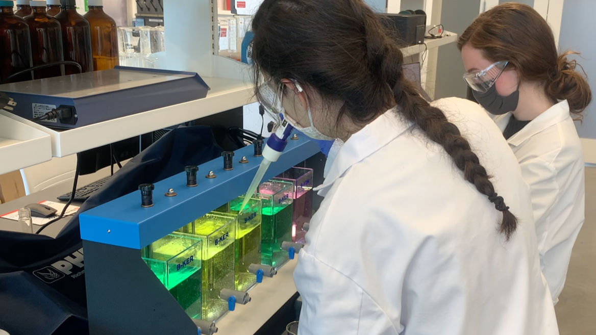 URI students Eloise Davis (left) and Megan Carless execute educational demonstrations of water treatment physicochemical processes. The CAREER award features educational and outreach demonstrations of ferrate.