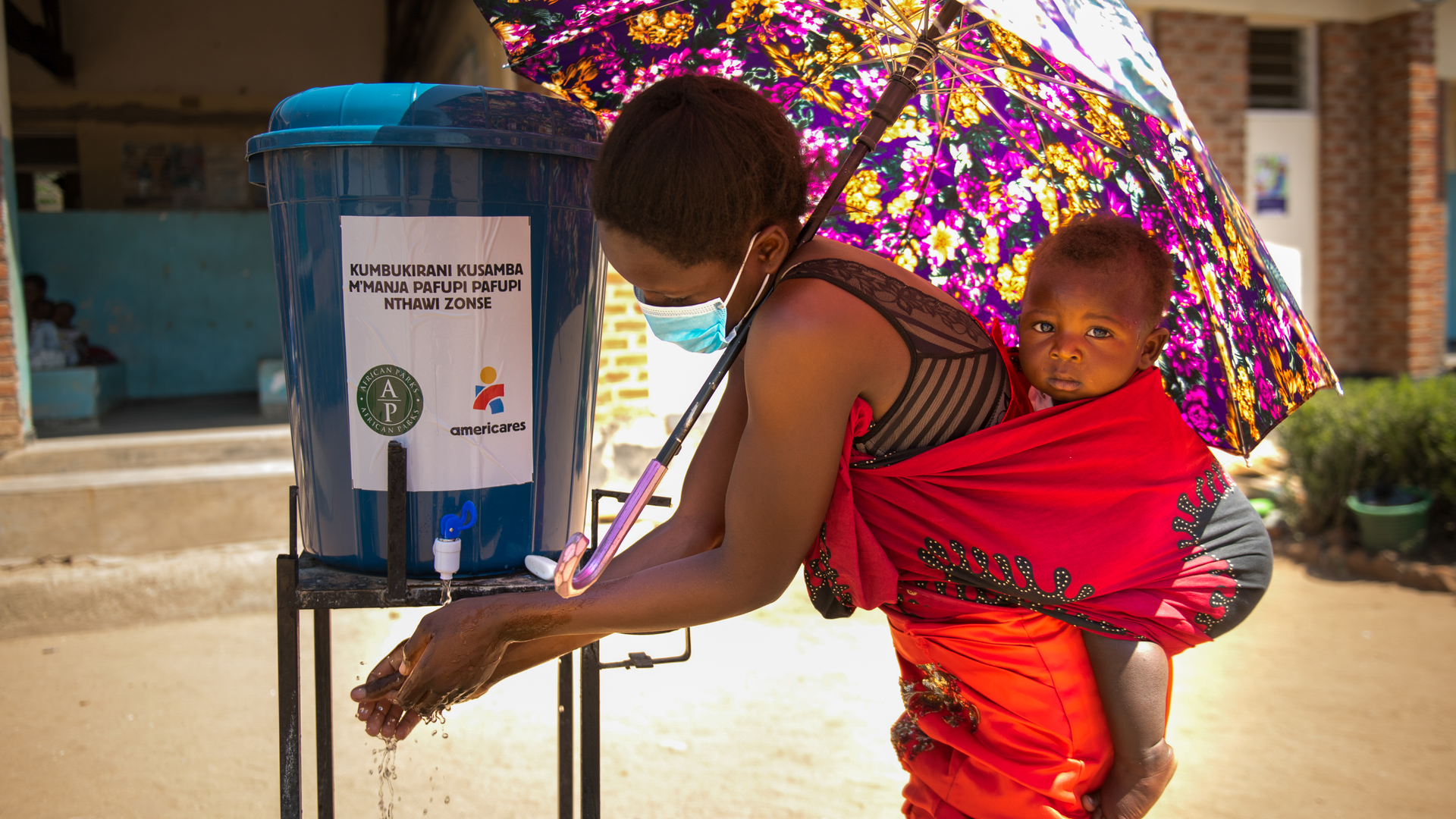 A woman washes her hands upon arrival at Namanolo Health Centre in Balaka Southern Malawi on November 18, 2020.