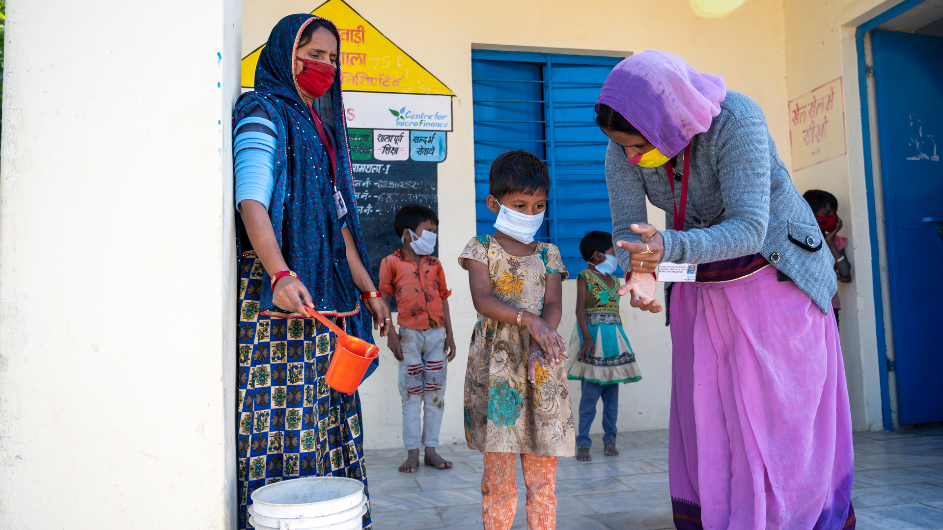 Caption - AWW and Sahaika demonstrate hand wash techniques to kids. Village Amthala, Abu Road, Rajasthan
