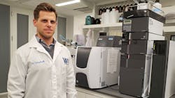 URI Assistant Professor Joseph Goodwill next to some of the state-of-the-art equipment used in the Water for the World Environmental Engineering Laboratory in the Fascitelli Center for Advanced Engineering.