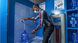 A customer fills up a large bottle with potable drinking water at a Diam&apos;O franchise kiosk in Dakar.