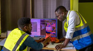 Feld Yelfaanibe, 27, product architect, and Obed Zar, 30, team lead, with Aquaset control boards at the Infitech lab in Tarkwa, Ghana. Oct. 24, 2022.
