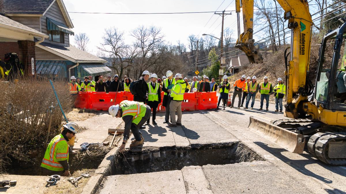 Local leaders, media, and PWSA staff look on as crews replace the 10,000th lead service in February 2023.
