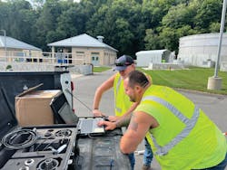 Employees Brandon Carter, lead utility technician (pictured, foreground) and Jim Ervin, foreman, perform a correlation for a leak based on data provided by its acoustic monitoring solution.