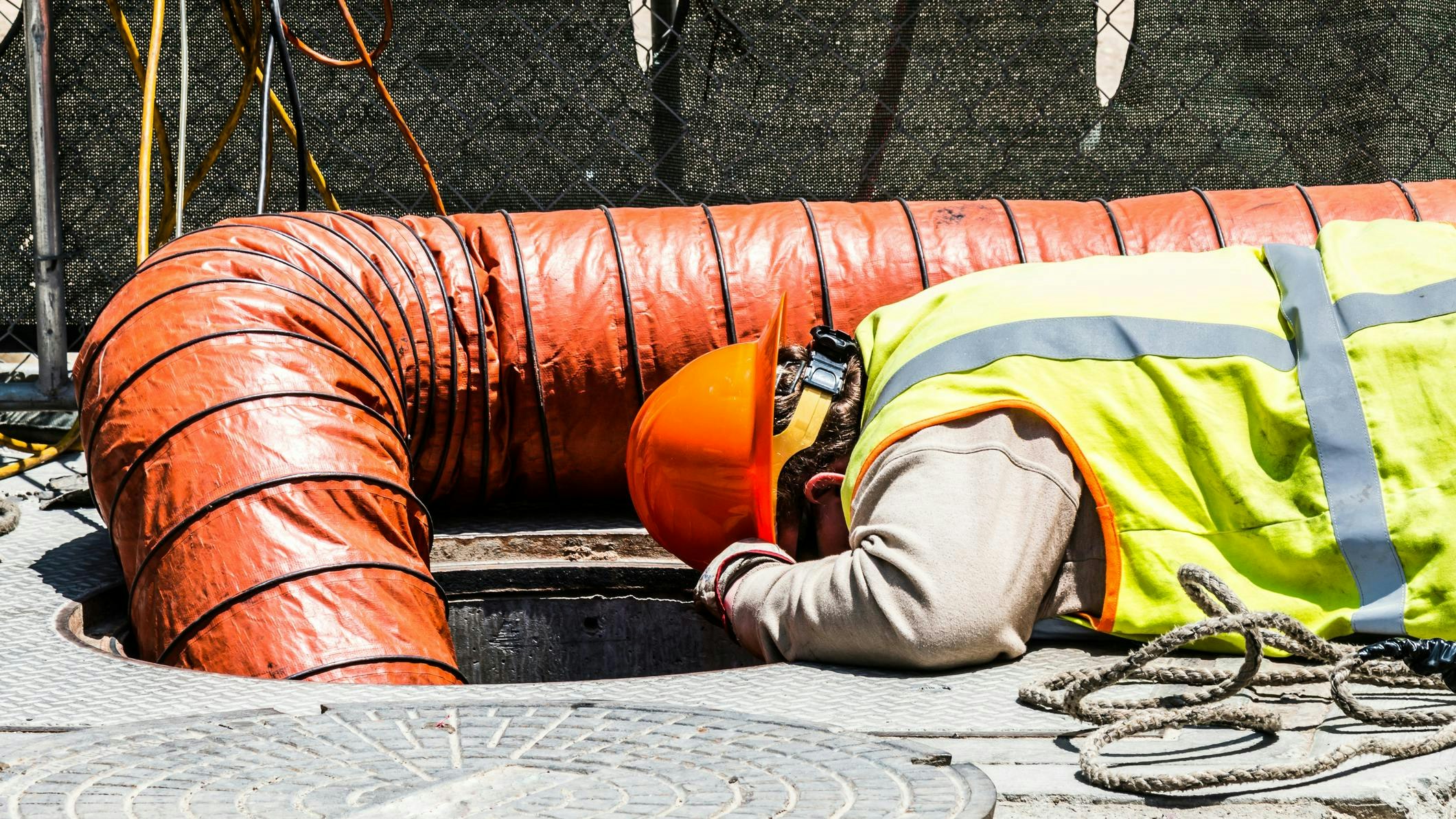 Worker Looking Down Manhole