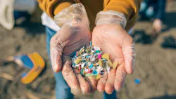 Hands with microplastics on the beach Hands with microplastics on the beach